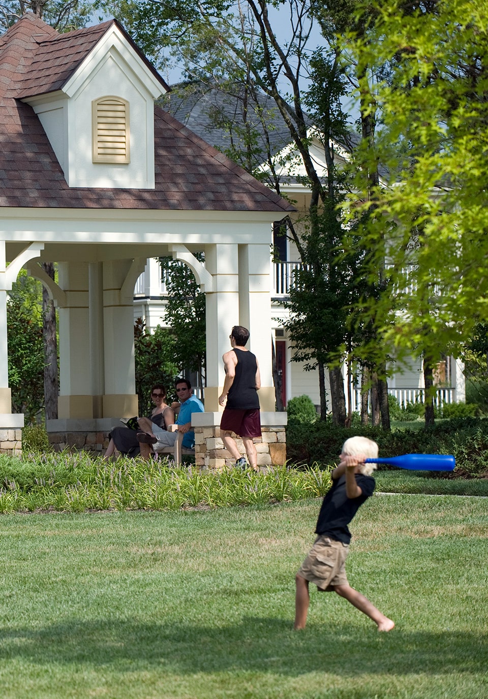 A boy playing baseball in a lawn