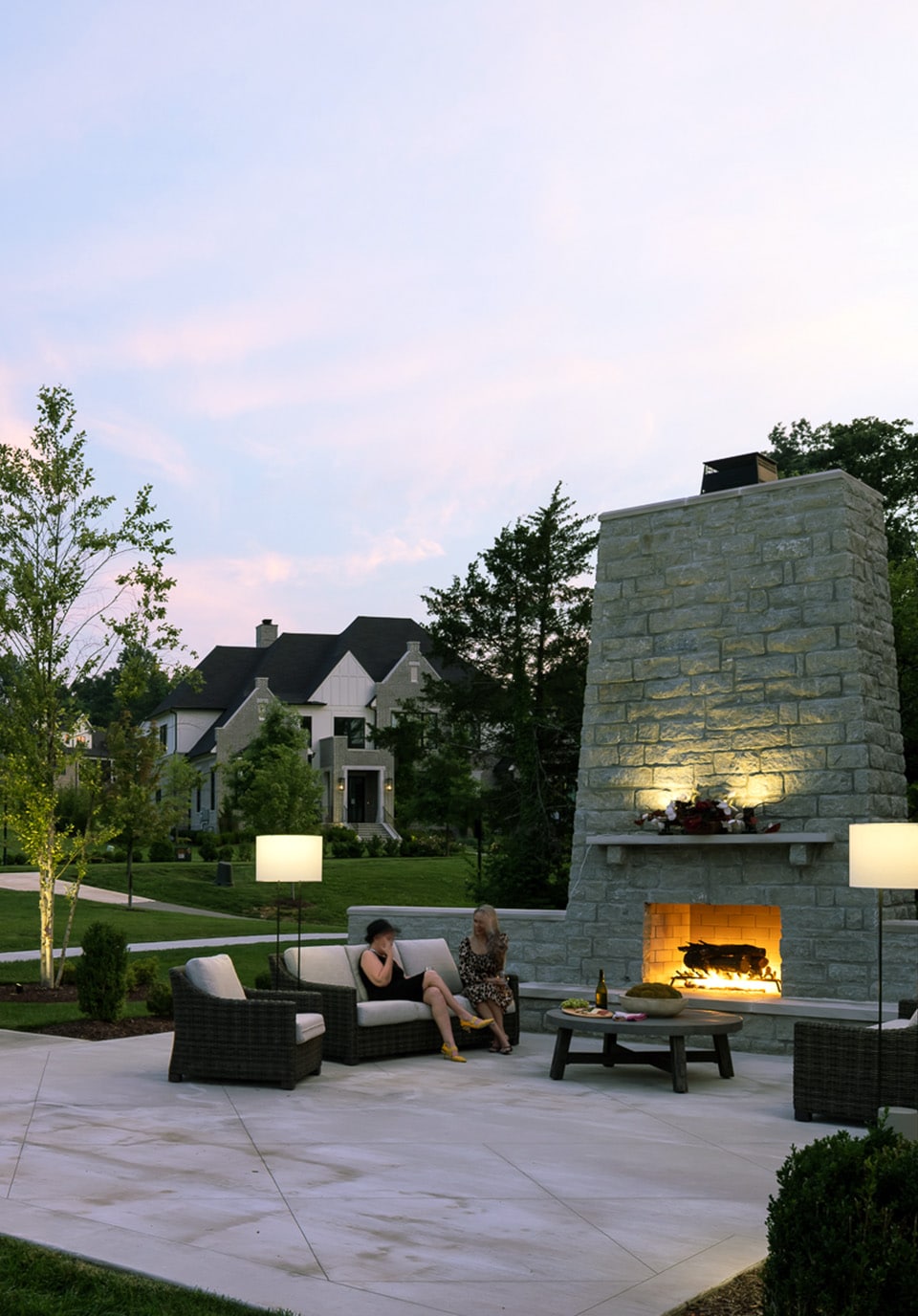 Two people sitting by a fire at dusk